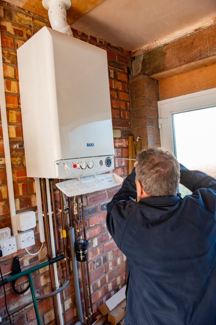 Gas Safe engineer installing a new boiler in a Lancashire home