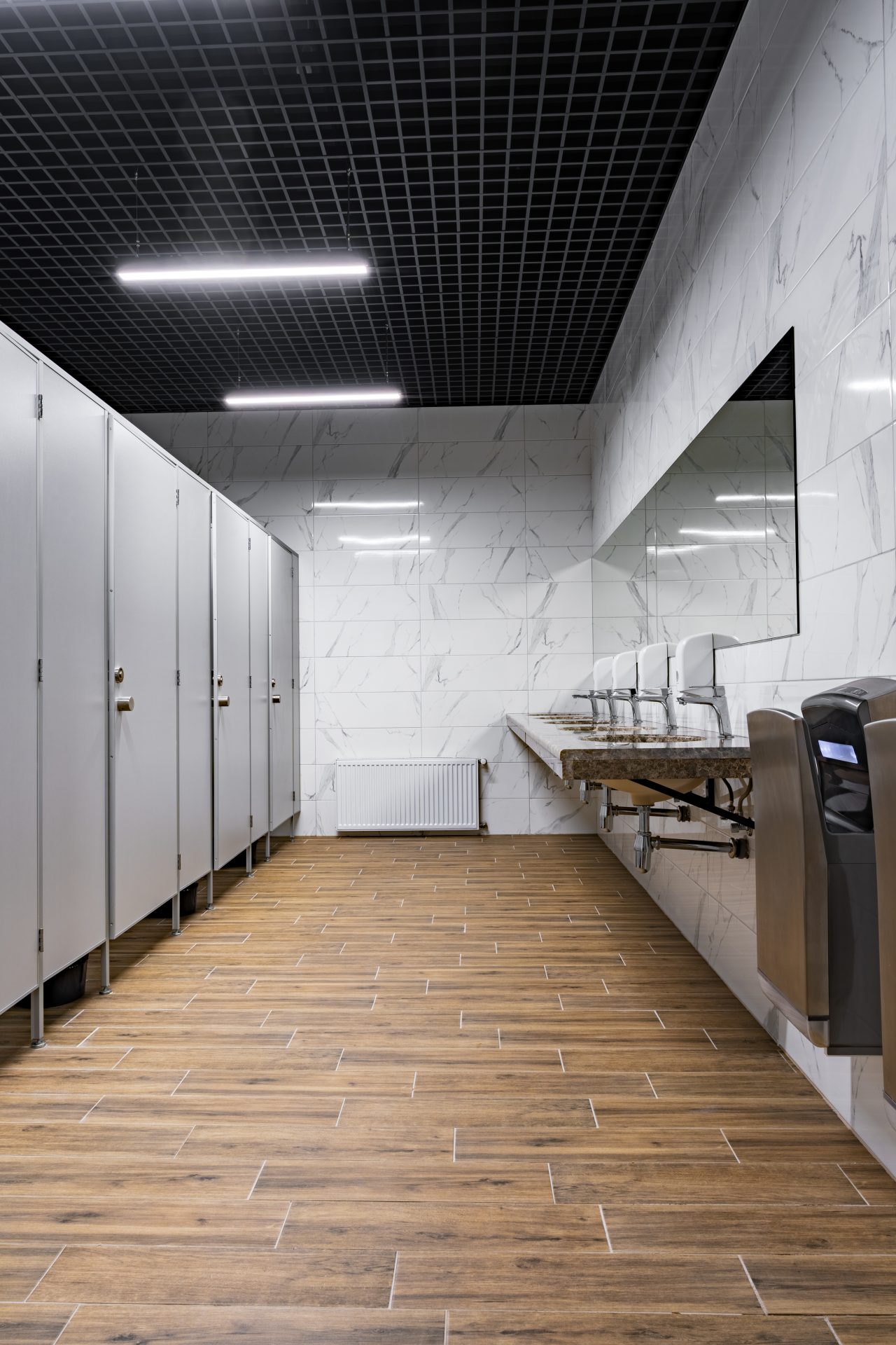 Commercial plumbing installation in modern washroom with multiple sinks and facilities
